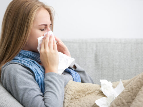 Sneezing woman on couch